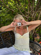 Woman taking a photo with a vintage camera outdoors