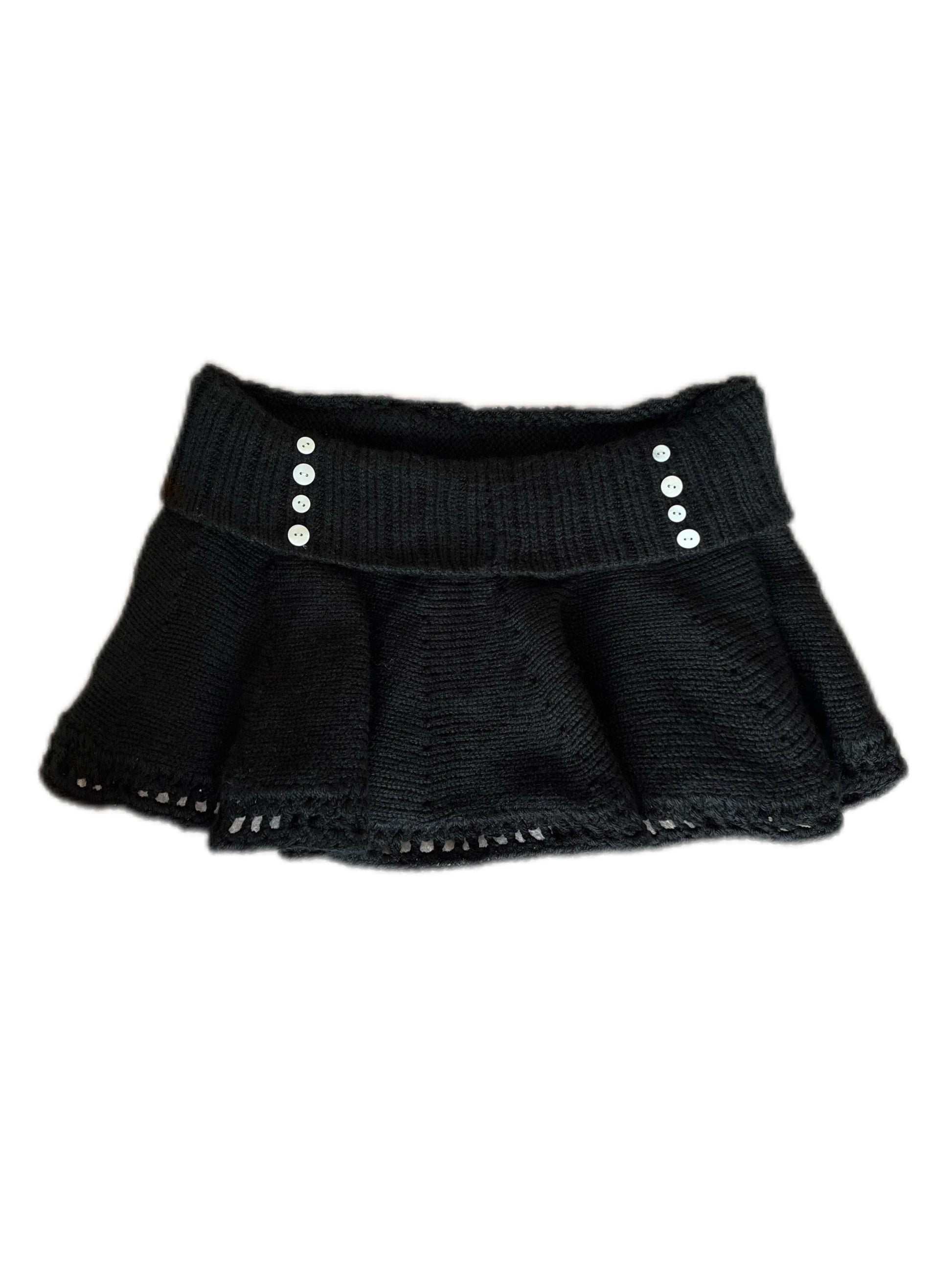 Black knit skirt with silver buttons on a white background