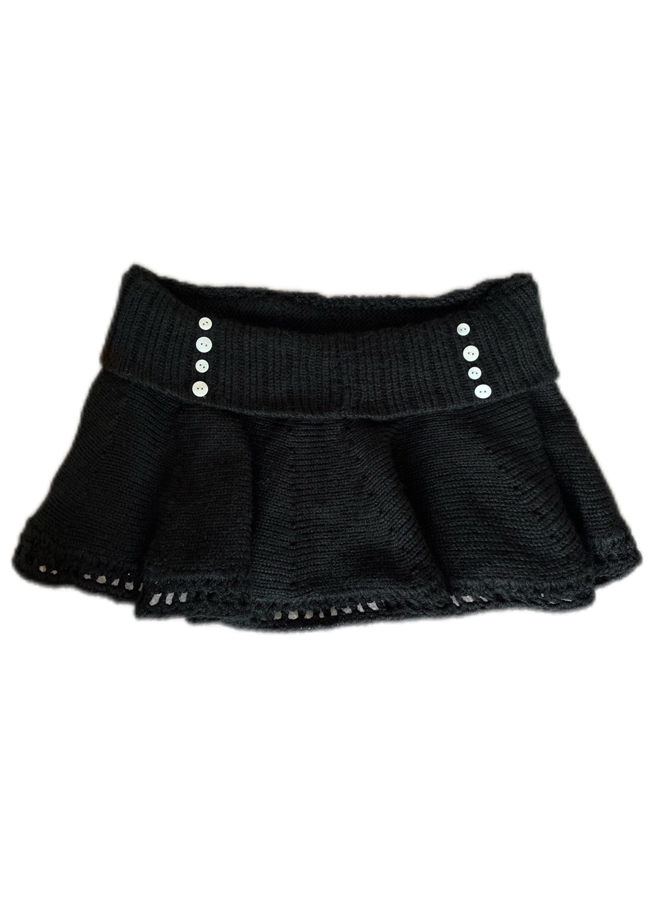 Black knit skirt with silver buttons on a white background